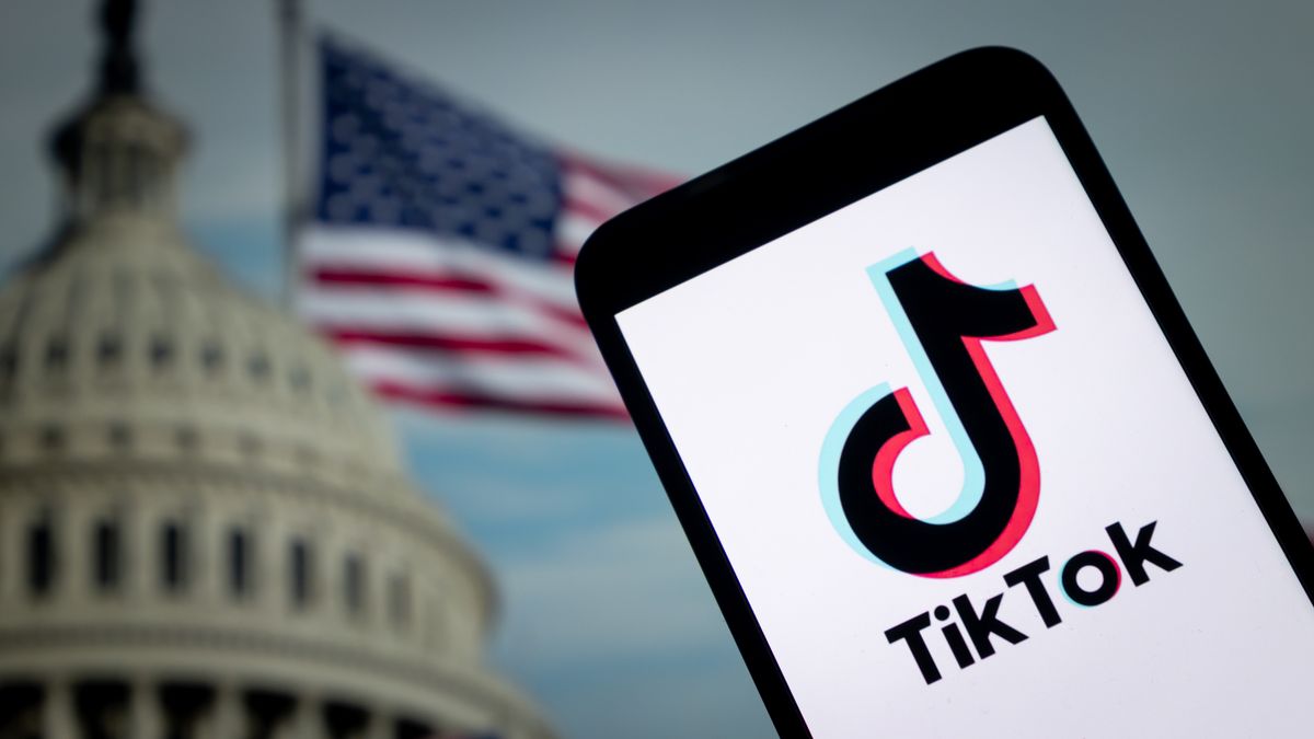CHONGQING, CHINA - SEPTEMBER 12: In this photo illustration, the logo of TikTok is displayed on smartphone screen with a US national flag in the background on September 12, 2025 in Chongqing, China. (Photo by Li Hongbo/VCG via Getty Images)