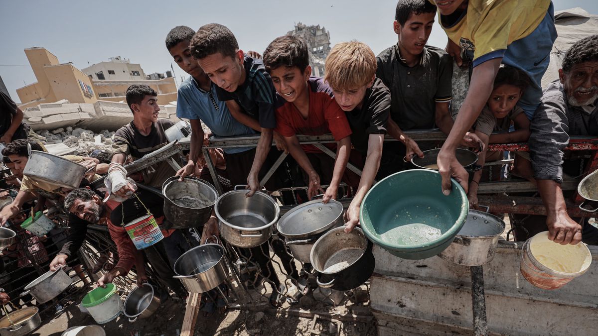 GAZA CITY, GAZA - JULY 30: Palestinians, including children, who are struggling to access food due to Israel's blockade and ongoing attacks on the Gaza Strip, wait in line to receive hot meals distributed by the charity organization in Gaza City, Gaza on July 30, 2025. Palestinians crowded together to get food. (Photo by Abdalhkem Abu Riash/Anadolu via Getty Images)