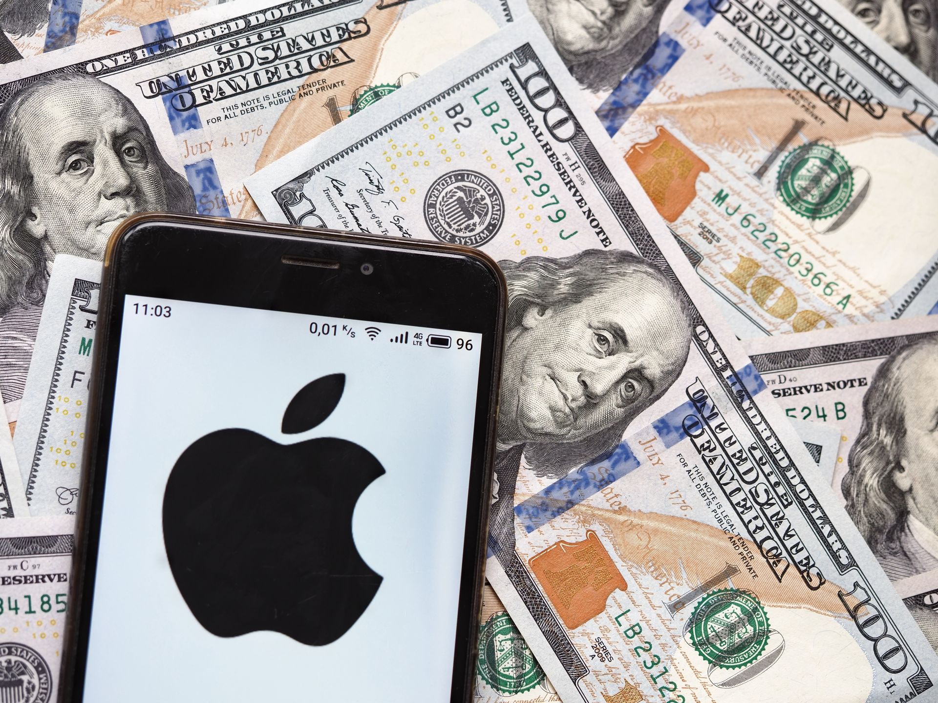 UKRAINE - 2020/09/04: In this photo illustration an Apple Inc. logo seen displayed on a smartphone with 100 dollar bills in the background. (Photo Illustration by Igor Golovniov/SOPA Images/LightRocket via Getty Images)