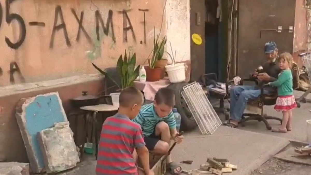 Dzieci bawią się obok zniszczonego bloku w Mariupolu 