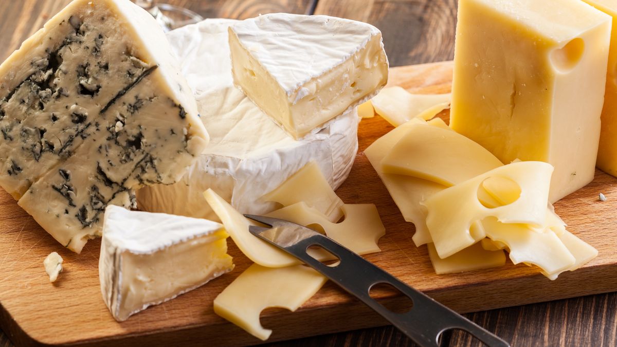 Set of different cheeses on a chopping boardcheeses, board, cutting, wooden, assorted, food, green, yellow, , horizontal, cheeses, board, cutting, wooden, assorted, food, green, yellow, cuisine, french, italian, slice, gourmet, meal, lunch, product, dairy, background, red, cut, table, closeup, appetizer, fruit, nobody, wine, glass, knife, horizontal