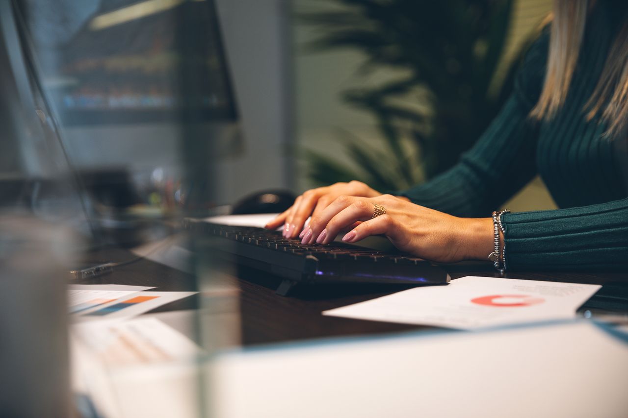 Woman at work typing on computer keyboard at the office.