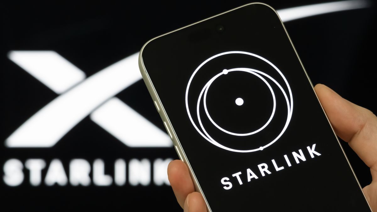CHONGQING, CHINA - FEBRUARY 3: In this photo illustration, a person holds a smartphone displaying the Starlink logo, with SpaceX branding visible in the background, on February 3, 2026, in Chongqing, China. The image follows reports that Elon Musk's aerospace company SpaceX is combining with his artificial intelligence venture xAI, a deal that would place xAI's assets, including the social media platform X, under SpaceX as Musk moves to consolidate his technology businesses and expand SpaceX's presence across communications, data and digital platforms. (Photo illustration by Cheng Xin/Getty Images)