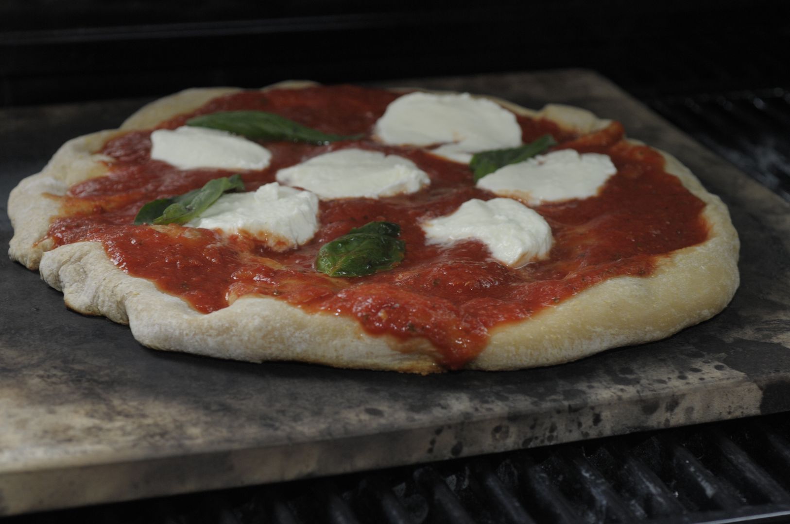 Brown's brown ale pizza dough with home made sauce, fresh mozzarella and fresh basil, cooks on a pizza stone on a grill at  DeFazio's Pizza on Thursday, June 13, 2013 in Troy, NY.   (Photo by Paul Buckowski/Albany Times Union via Getty Images)