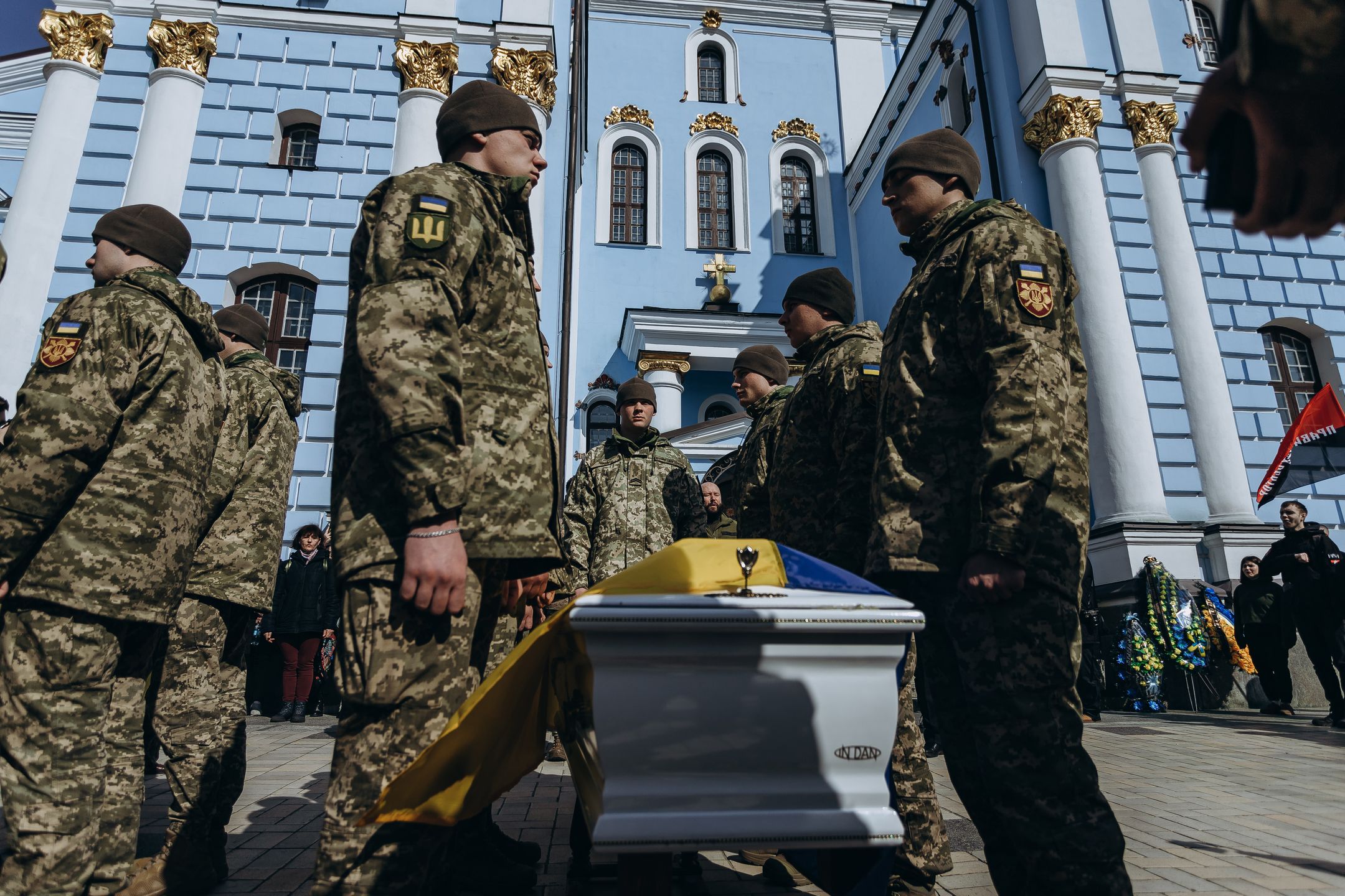 KYIV, UKRAINE - MARCH 21: An honor guard stands around a coffin covered with Ukrainian flag during a farewell ceremony for 22-year-old combat medic of the 67th Mechanized Brigade Anastasiia Marianchuk with the call sign ‘Troy’ on March 21, 2024 in Kyiv, Ukraine. Anastasia died on March 18, 2024 in Donetsk Oblast, evacuating wounded Ukrainian soldiers from Russian shelling. Before the full-scale Russian invasion of Ukraine, she studied Japanese philology at the Taras Shevchenko National University of Kyiv. (Photo by Valentyna Polishchuk/Global Images Ukraine via Getty Images)