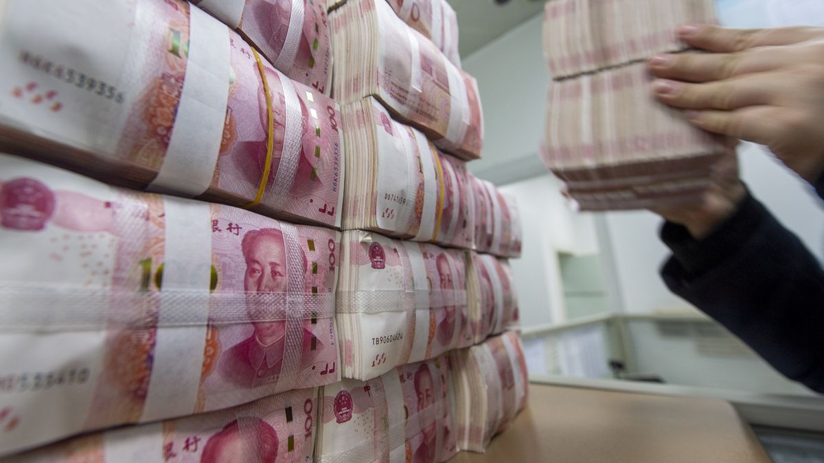 HAIAN, CHINA - DECEMBER 31 2021: A clerk counts renminbi banknotes at a bank outlet in Haian city in east Chinas Jiangsu province Friday, Dec. 31, 2021. Yuan appreciated by 1,492 base points against the US dollar this year. (Photo credit should read XU JINBAI/Future Publishing via Getty Images)