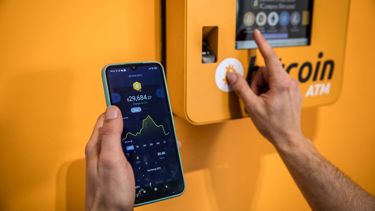 A customer inspects a Bitcoin price chart whilst using a cryptocurrency automated teller machine (ATM) inside a BitBase cryptocurrency exchange arranged in Barcelona, Spain, on Monday, May 16, 2022. The wipeout of algorithmic stablecoin TerraUSD and its sister token Luna knocked more than $270 billion off the crypto sectors total trillion-dollar value in the most volatile week for Bitcoin trading in at least two years. Photographer: Angel Garcia/Bloomberg via Getty Images