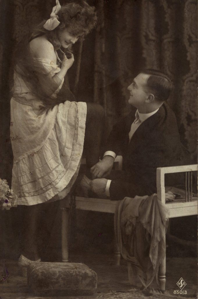 Pocztówka z początku XX wieku. Mężczyzna na ławce złośliwie nie chce zrobić miejsca dla swojej towarzyszki