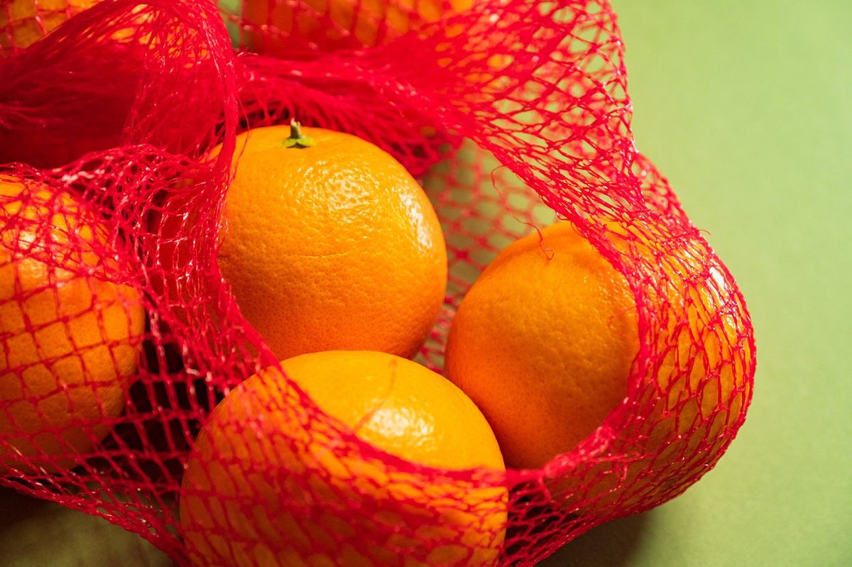 Why do oranges in red mesh bags look riper and tastier