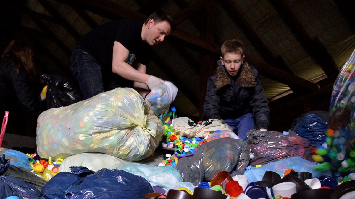 Wolontariusze krakowskiej fundacji "Bez Tajemnic" segregują i przepakowują plastikowe zakrętki w magazynie w Krakowie