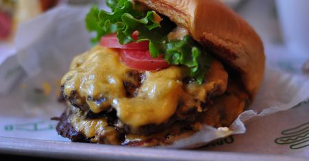 Powiększony cheeseburger z przyprawami i warzywami