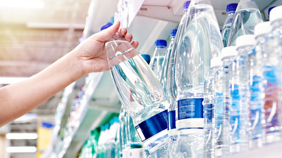 Kobieta sięga po butelkę wody.