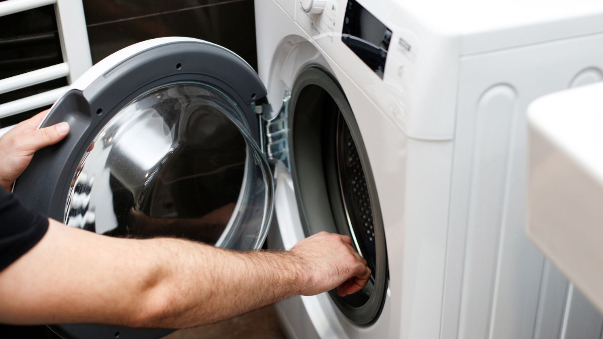 Mężczyzna otwiera pralkę