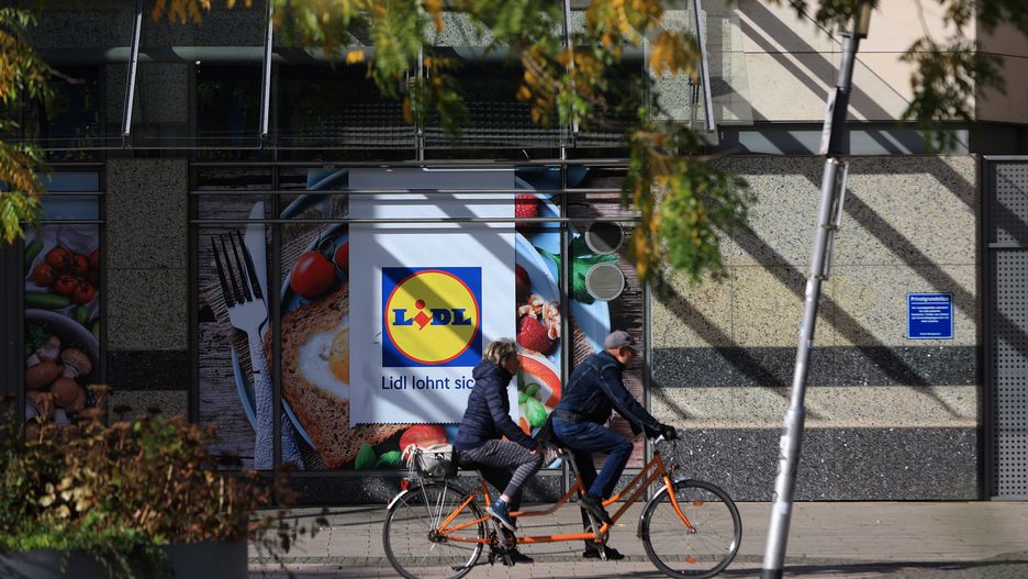 Cyclists ride a tandem bike past a Lidl supermarket in Magdeburg, Germany, on Monday, Oct. 30, 2023. German inflation slowed markedly  and more than expected  in October as Europe's biggest economy struggles to grow. Photographer: Krisztian Bocsi/Bloomberg via Getty Images