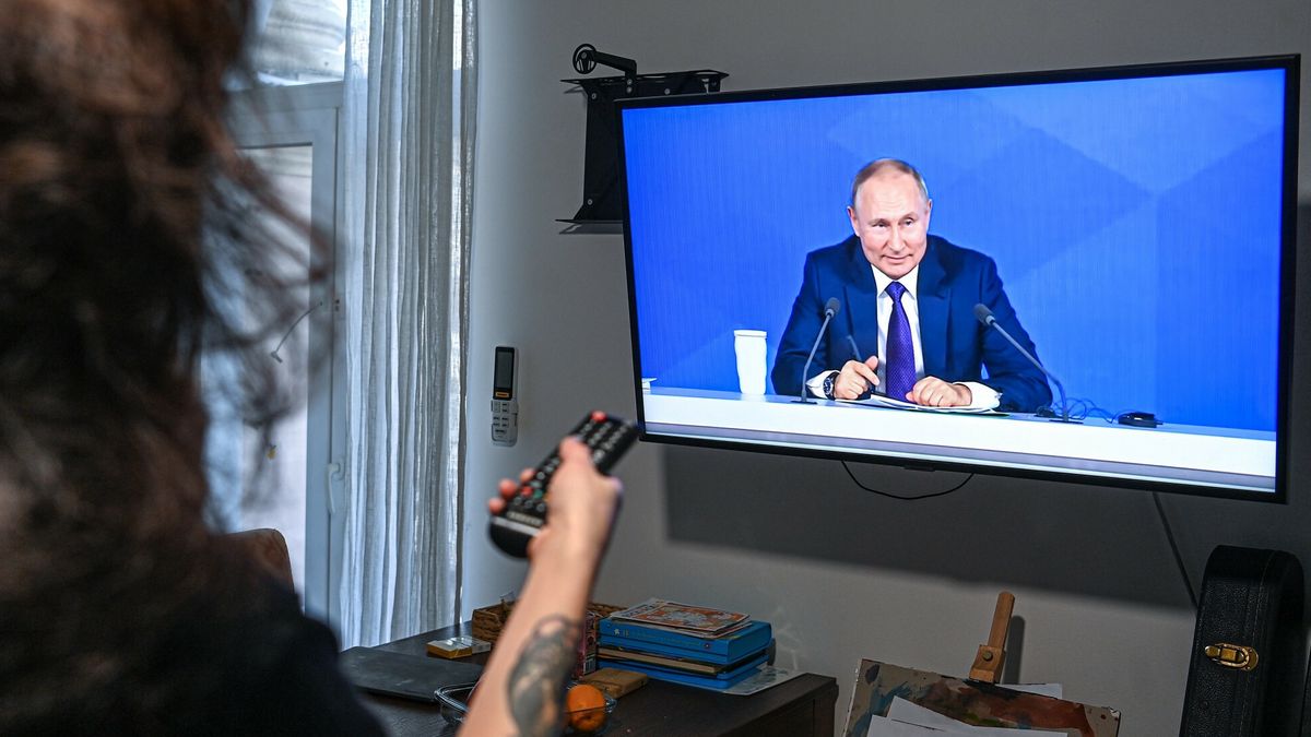 Doroczna konferencja W?adimira Putina6728640 23.12.2021 A woman watches a TV broadcast showing the annual end-of-year news conference of Russian President Vladimir Putin, in Moscow, Russia. Evgeny Odinokov / SputnikEvgeny Odinokov