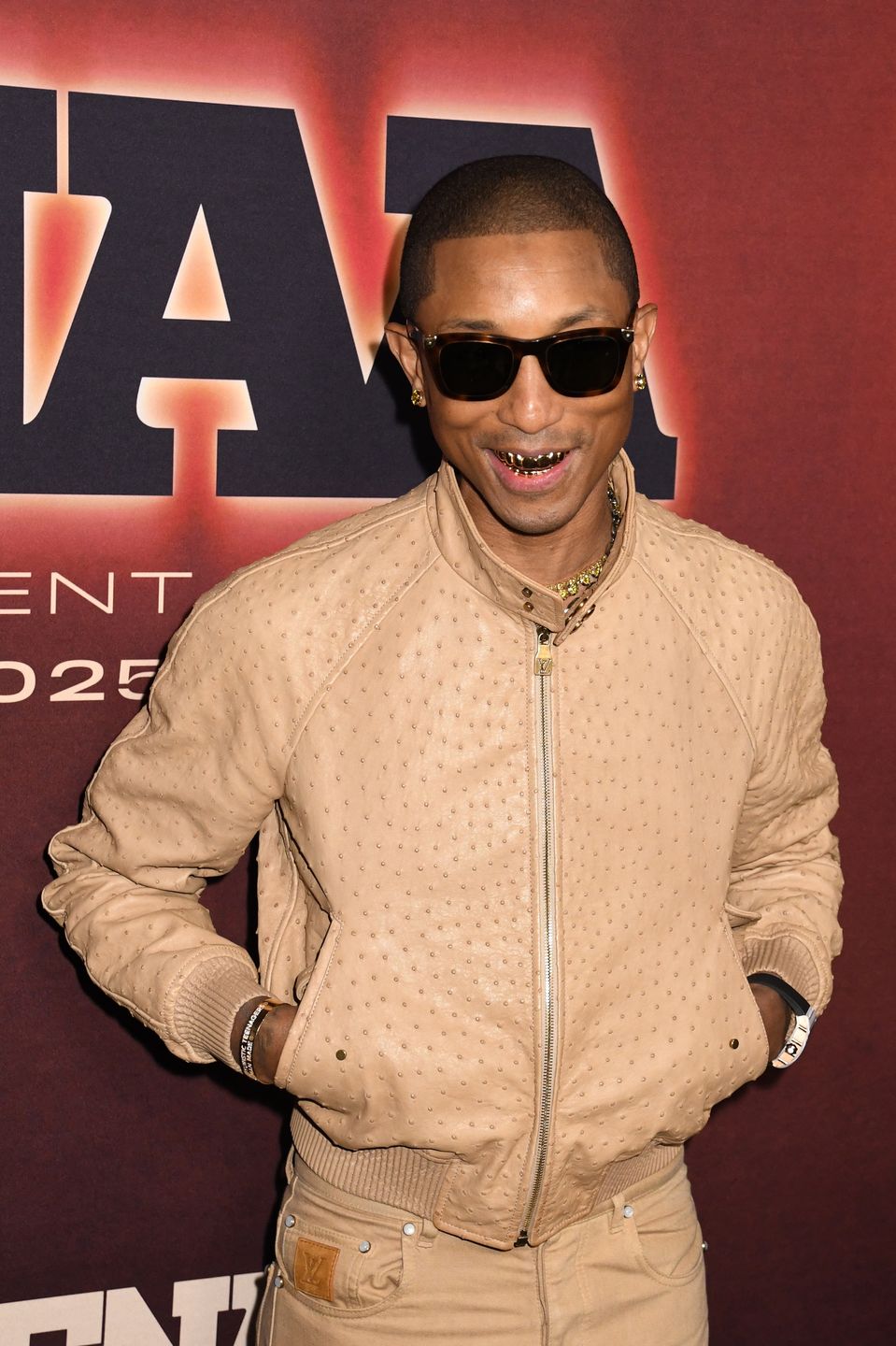 Pharrell Williams oślepia złotym uśmiechem na ściance