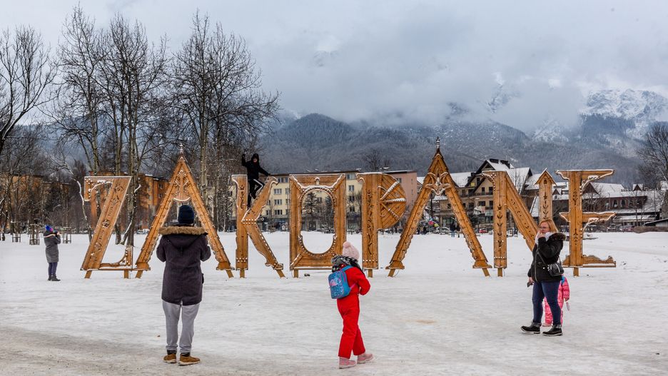 ZAKOPANE, MALOPOLSKIE, POLAND - 2024/01/19: Families take a photo in a public park in front of Zakopane sign in the center of Zakopane a popular Tatra mountain holiday resort. (Photo by Dominika Zarzycka/SOPA Images/LightRocket via Getty Images)