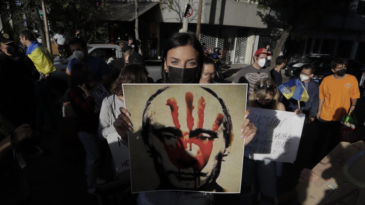 A member of the Ukrainian community holds a placard while protesting outside the Russian Embassy in Mexico City against Russian President Vladimir Putin, after he ordered the start of a military strategy and offensive in several Ukrainian cities. (Photo by Gerardo Vieyra/NurPhoto via Getty Images)