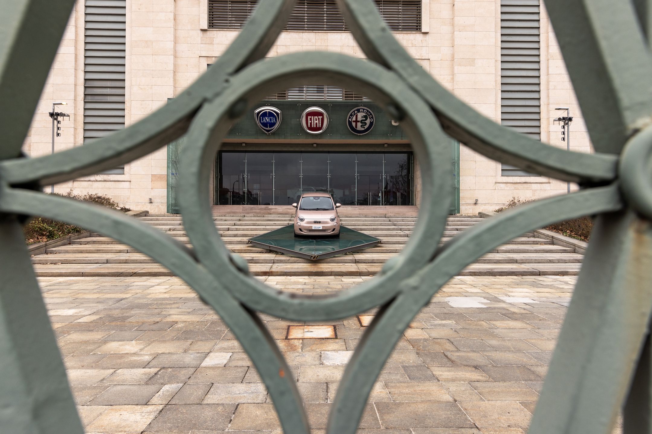 A Fiat 500e is being displayed at the entrance to the Stellantis factory in Mirafiori, Turin, Italy, on February 24, 2024. The Ecological Left (Sinistra Ecologista) and the Left Greens (Verdi) are organizing a march around the FIAT Mirafiori plant, a significant symbol of Italian industry, demanding complete and quality employment opportunities during the ecological transition phase and calling for a halt to relocations and layoffs. (Photo by Mauro Ujetto/NurPhoto via Getty Images)