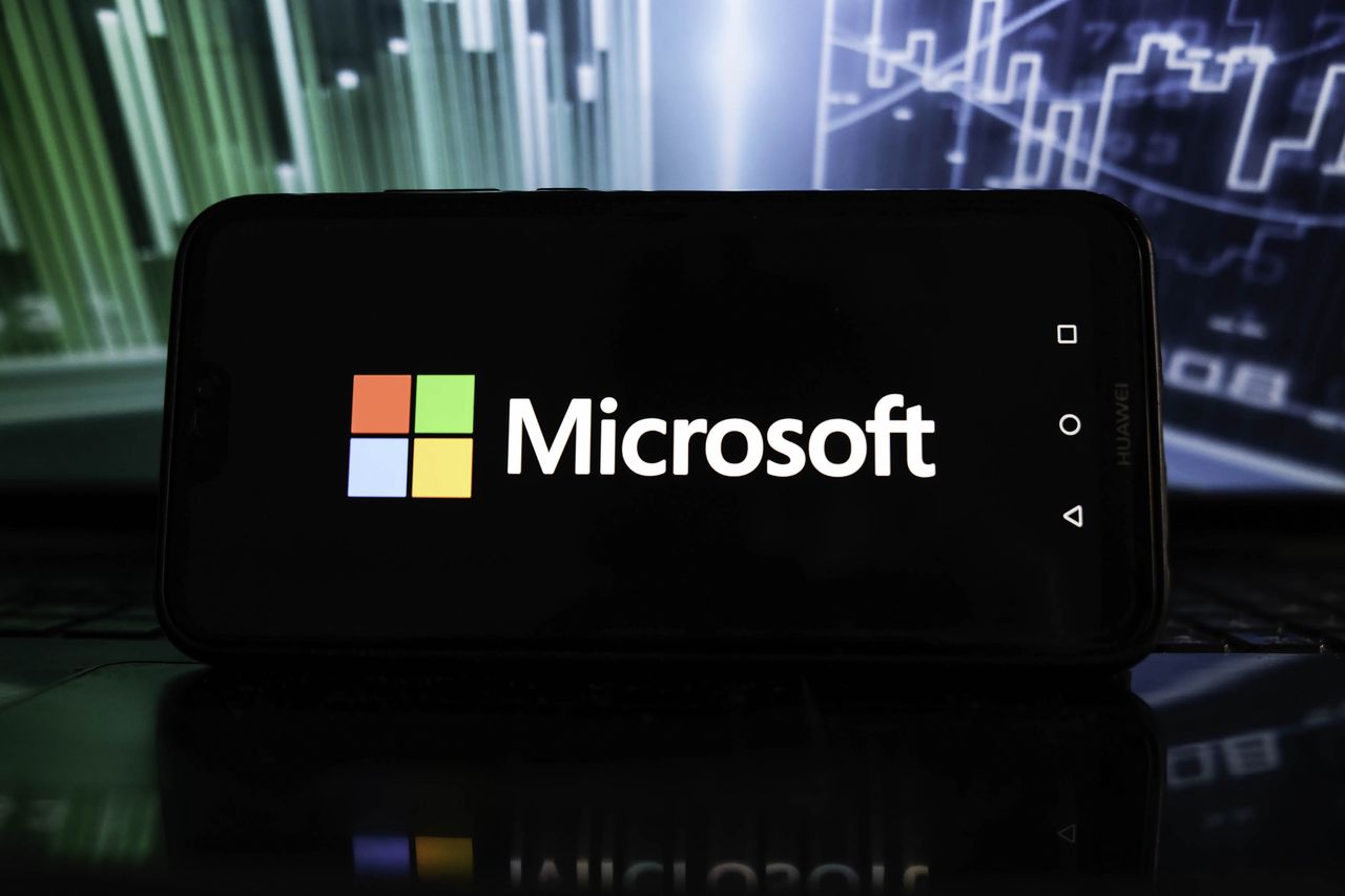 POLAND - 2022/01/19: In this photo illustration a Microsoft logo is displayed on a smartphone with stock market percentages on the background. (Photo Illustration by Omar Marques/SOPA Images/LightRocket via Getty Images)