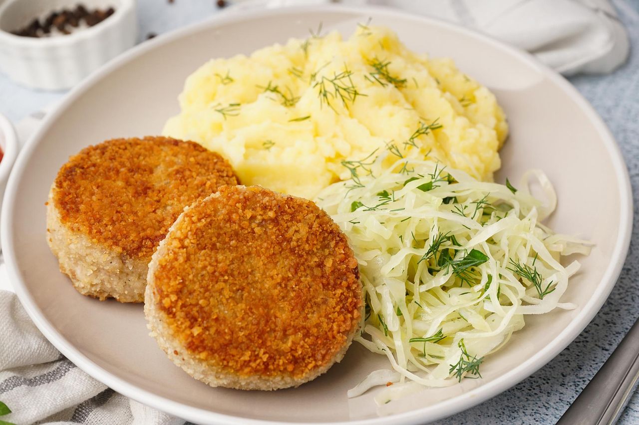 Kotlet mielony z ziemniakami i surówką na talerzu
