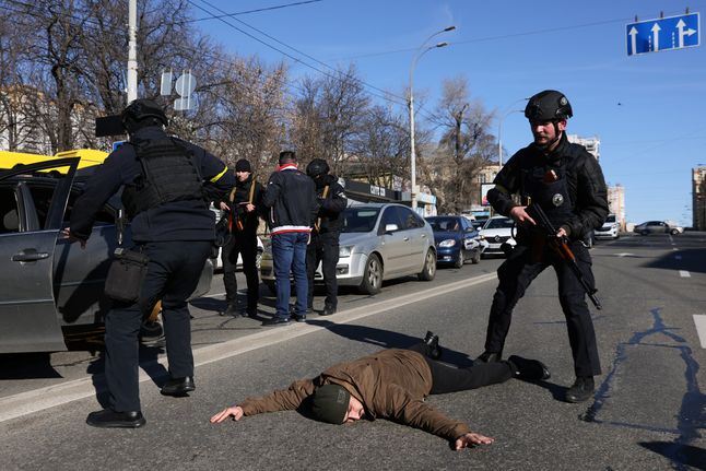 Policja sprawdza ludzi z podejrzanego samochodu na ulicy Kijowa.