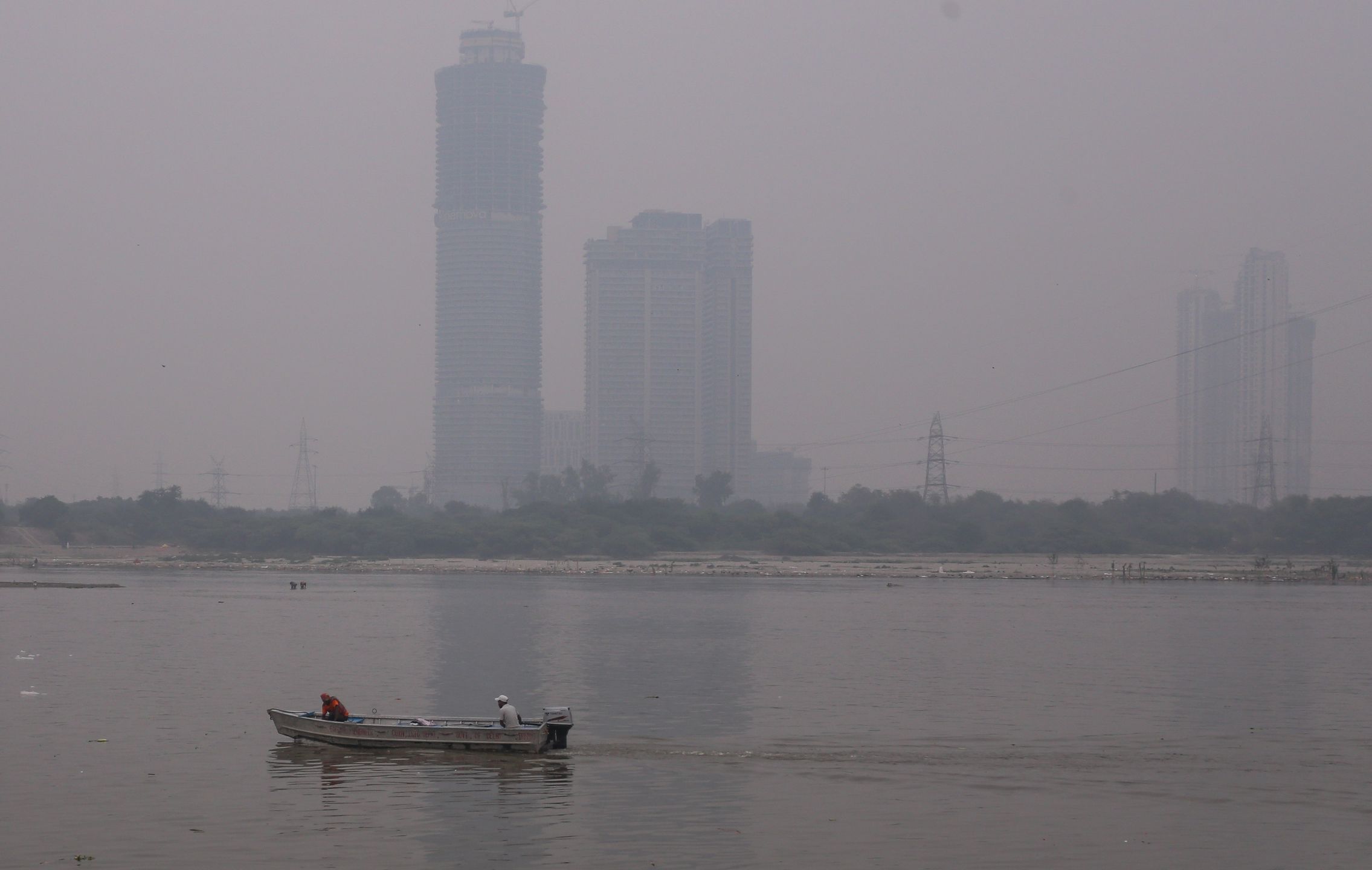 NEW DELHI, INDIA - OCTOBER 29: Workers move on a boat in Yamuna river amid heavy smog pollution on October 29, 2025 in New Delhi, India. Delhi is once again blanketed by hazardous smog following the Diwali festival, as pollution levels spike to the "very poor" and "severe" categories, with air quality indexes far exceeding safe limits. The crisis, which is driven by firecracker use, emissions, and seasonal crop residue burning has prompted emergency measures like cloud seeding. (Photo by Ritesh Shukla/Getty Images)