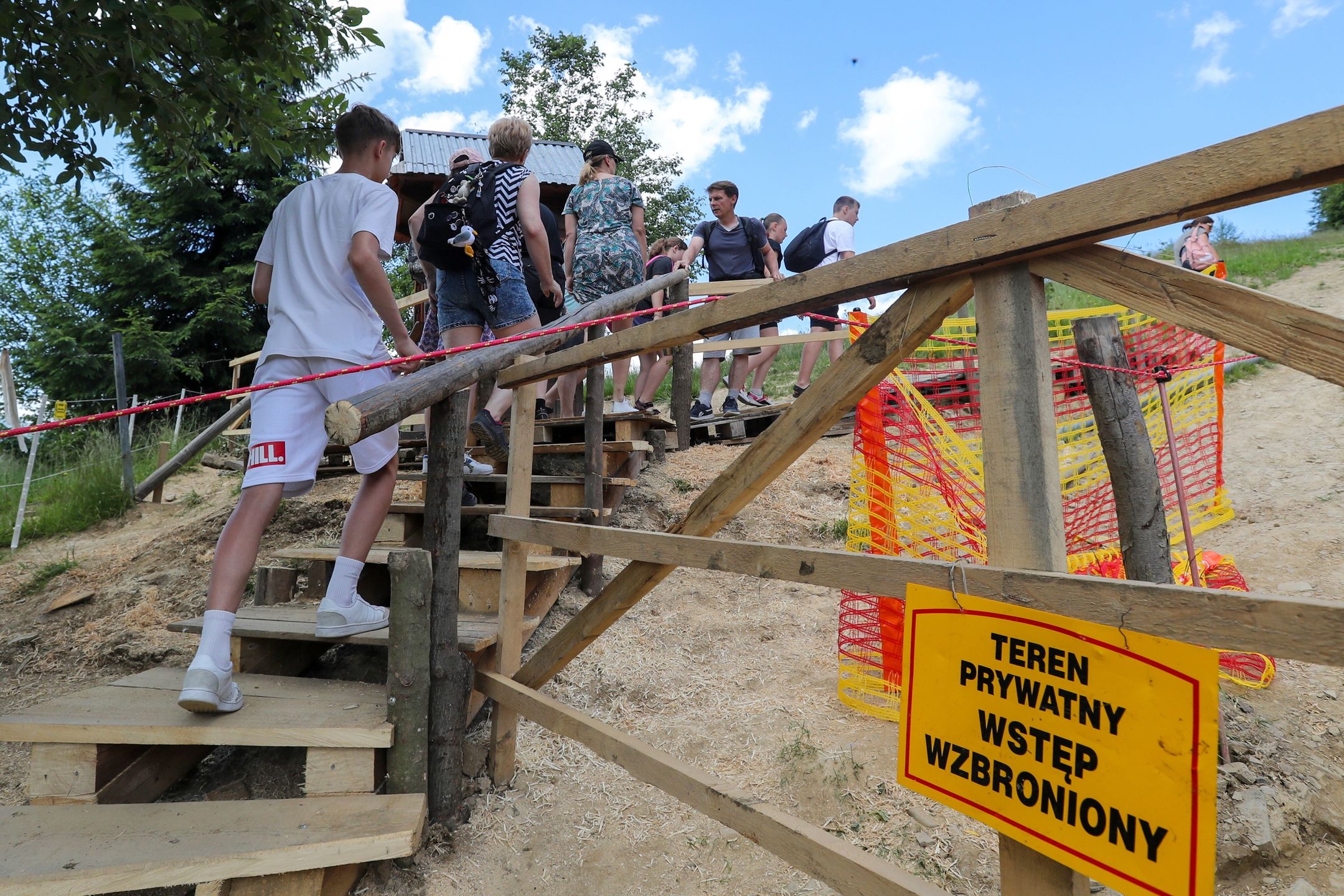 Zakopane, 05.07.2023. Właściciele prywatnych gruntów pobierają opłaty od turystów za przejście szlakiem na Gubałówkę, 5 bm. Pobieranie opłaty 5 zł uzasadniają prawem własności gruntów, przez które przebiega szlak. Nie ma możliwości przejścia za darmo, również przez szlak wytyczony przez PKL wzdłuż kolejki. (mr) PAP/Grzegorz Momot