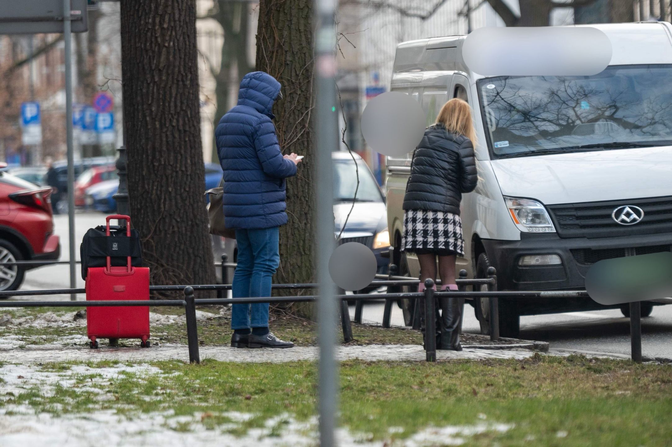 Monika Olejnik w krótkiej spódnicy czeka przy ulicy z walizkami