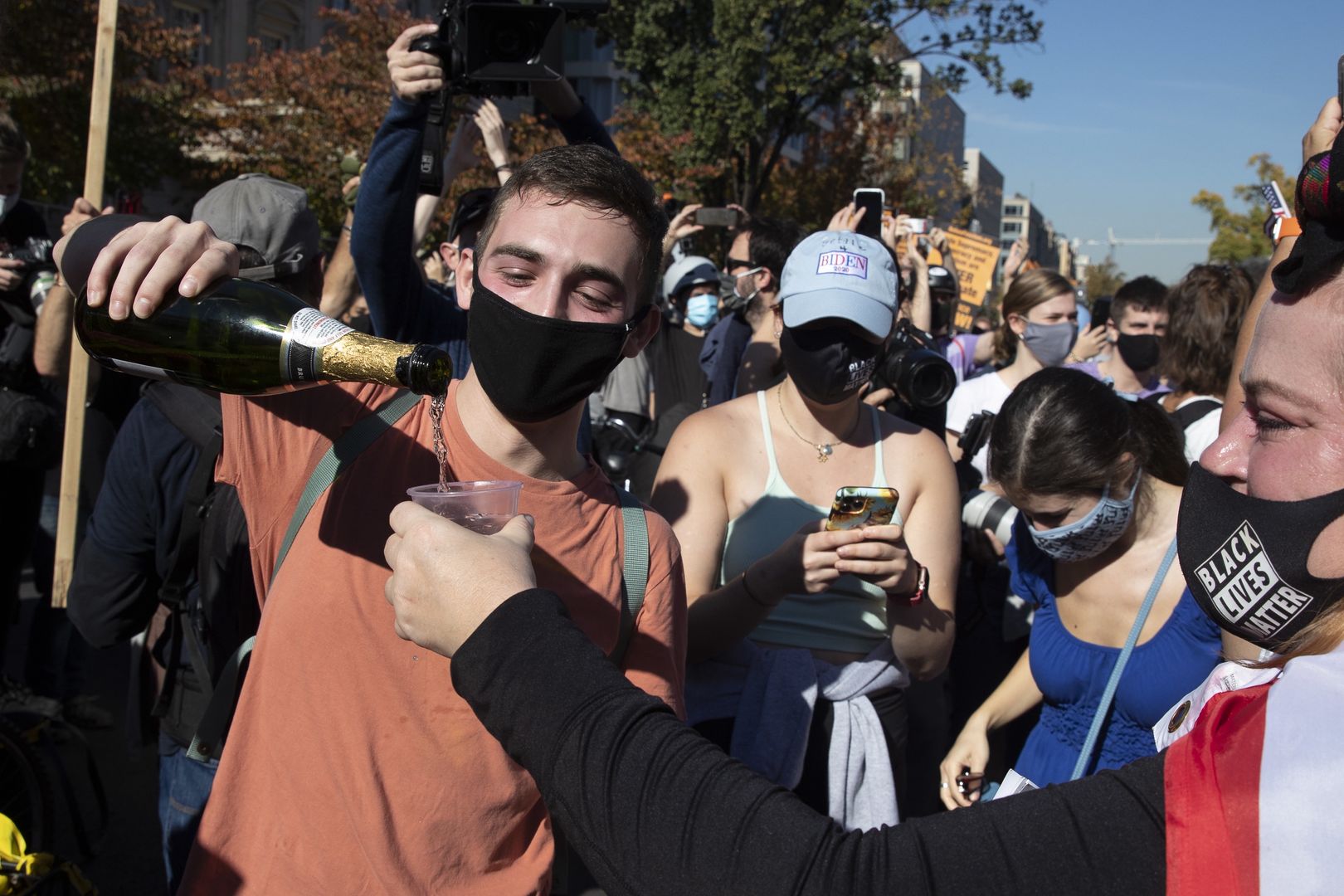 Młodzi Amerykanie świętują z szampanem zwycięstwo Bidena w Waszyngtonie niedaleko Białego Domu
