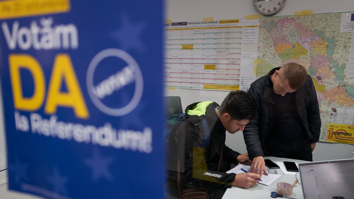 CHISINAU, MOLDOVA - OCTOBER 16: A supporter of the pro-European Union incumbent president, Maia Sandu, fills out paperwork at the Party of Action and Solidarity headquarters to make a legal donation of 2,000 lei, equivalent to approximately 100 euros on October 16, 2024 in Chisinau, Moldova. The poster urges voters to vote "Yes" in the European Union referendum. Earlier this month, police uncovered a $15 million vote-buying scheme allegedly funded by Russia, involving individuals linked to fugitive businessman Ilan Shor. Moldova will hold its presidential election on Sunday, with incumbent pro-EU President Maia Sandu facing former prosecutor Alexandr Stoianoglo, backed by the pro-Russian Socialist Party, and nine other candidates. Voters will also decide in a referendum whether to amend the constitution to make EU membership an official national goal. (Photo by Pierre Crom/Getty Images)