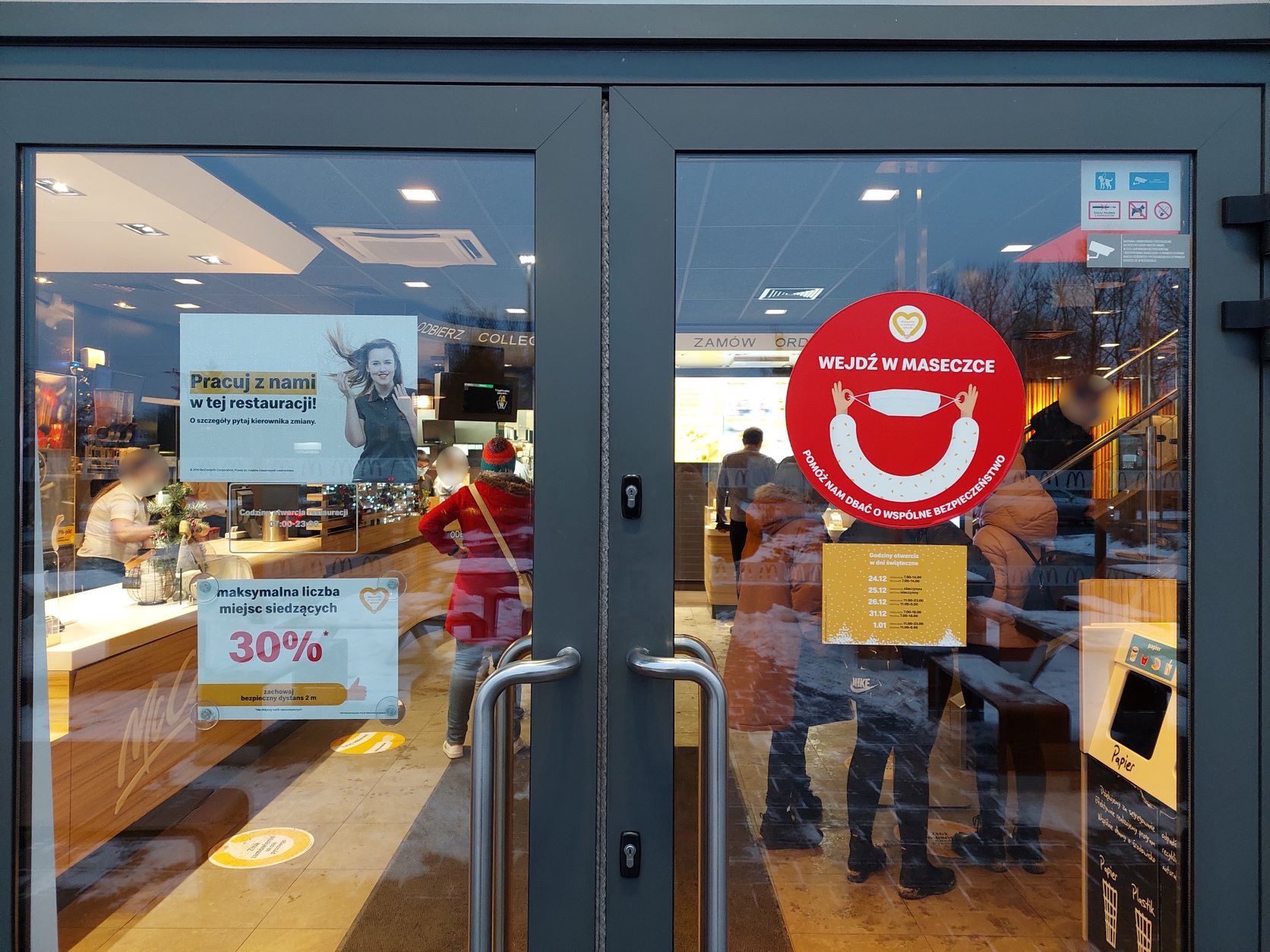 Drzwi wejściowe do restauracji McDonald's w Kobyłce. Na szybie znajdują się informacje m.in. o obowiązku noszenia maseczki oraz o ograniczeniu miejsc siedzących do 30 proc.