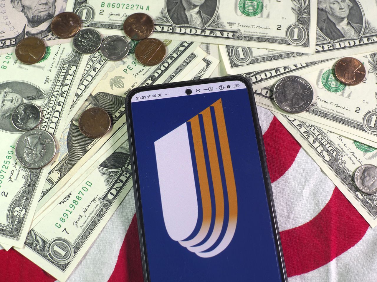 GERMANY - 2023/09/01: In this photo illustration, a UnitedHealth Group Inc logo is seen displayed on a smartphone and US currency notes and coins in the background. (Photo Illustration by Igor Golovniov/SOPA Images/LightRocket via Getty Images)