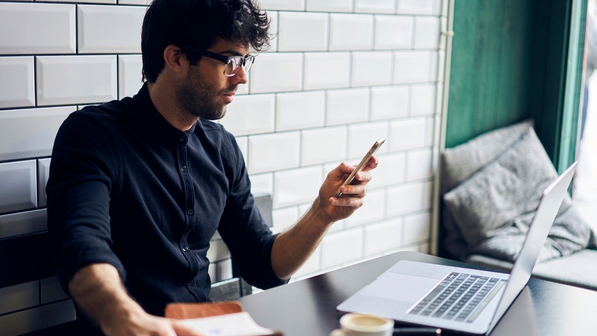 Mężczyzna korzystający ze smartfonu i laptopa z depositphotos