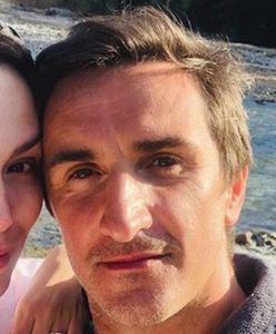 Sebastian Karpiel-Bułecka pozuje na motocyklu. Jego strój jest dośc nietypowy