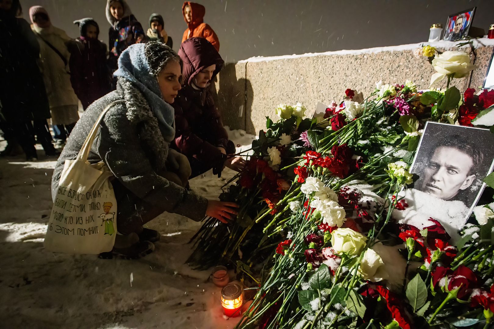People lay flowers at a spontaneous memorial in memory ofST  PETERSBURG, RUSSIA - 2024/02/16: People lay flowers at a spontaneous memorial in memory of the deceased Russian opposition leader Alexei Navalny, organized at the monument to victims of political repression on Voskresenskaya Embankment. Russian opposition leader Alexei Navalny reportedly died in the IK-3 prison colony, known as the "Polar Wolf," in the Yamalo-Nenets Autonomous Okrug, according to the press service of the Federal Penitentiary Service. Prison authorities indicated that Navalny felt unwell after a walk on Friday. He was last seen in good spirits during a court video link appearance just a day before. (Photo by Artem Priakhin/SOPA Images/LightRocket via Getty Images)SOPA Imagescommemoration, deceased, died, floral tributes, flowers, memory, opposition leader, political repression, spontaneous memorial, tribute, victims, voskresenskaya embankment