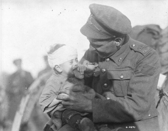 Kanadyjski żołnierz pociesz belgijskie dziecko po tym jak doznało obrażeń, a jego matka zginęła (1918).