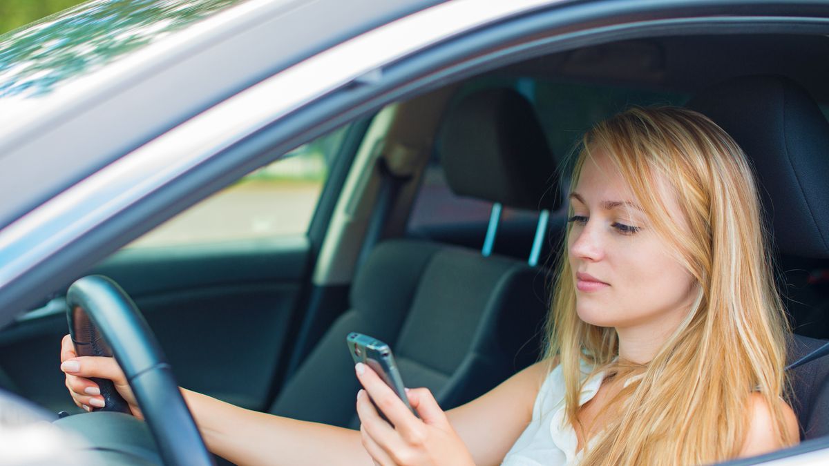 Zdjęcie kobiety używającej telefonu w aucie