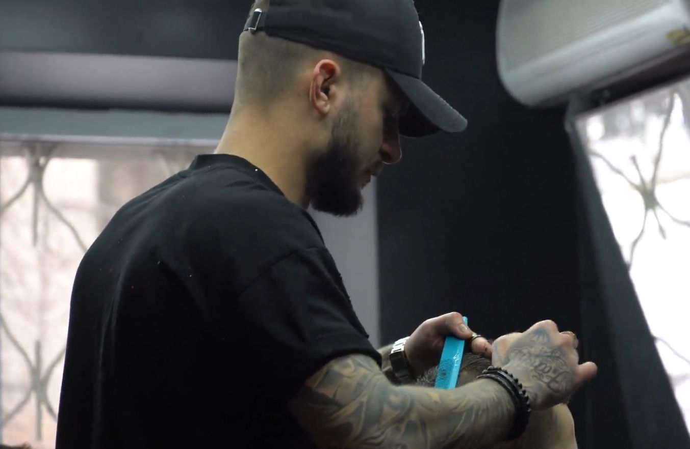 Dmytro, współwłaściciel barber shopu, strzyże wojskowego.