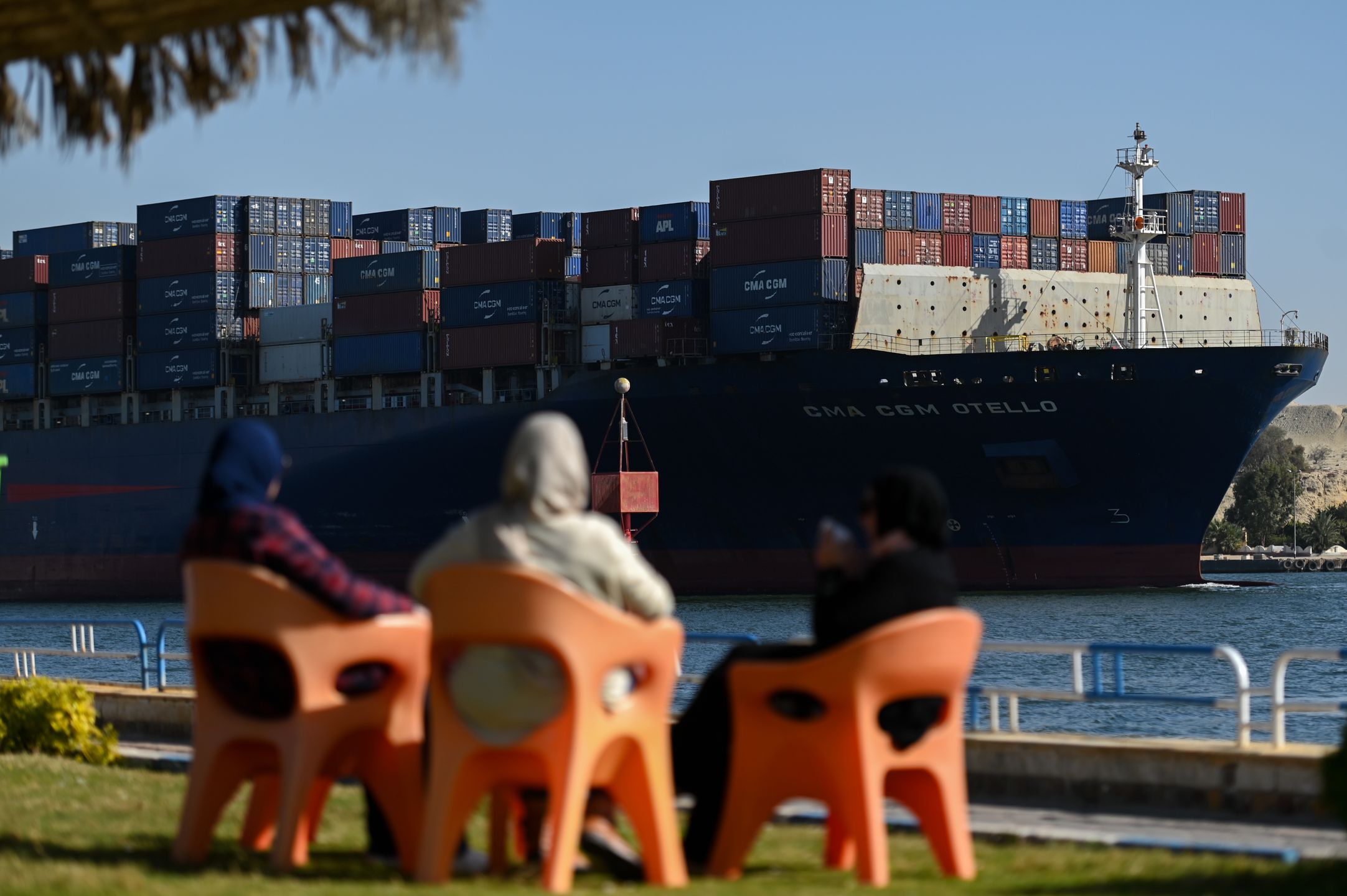 ISMAILIA, EGYPT - JANUARY 10: People watch as a ship transits the Suez Canal towards the Red Sea on January 10, 2024 in Ismailia, Egypt. In the wake of Israel's war on Gaza after the October 7 Hamas attack on Israel, Houthi rebels in Yemen pledged disruption on all ships destined for Israel through the Red Sea's Suez Canal. The disruption on world trade is evident in the number of companies using this container ship route - a 90 per cent decline compared to figures one year ago. (Photo by Sayed Hassan/Getty Images)