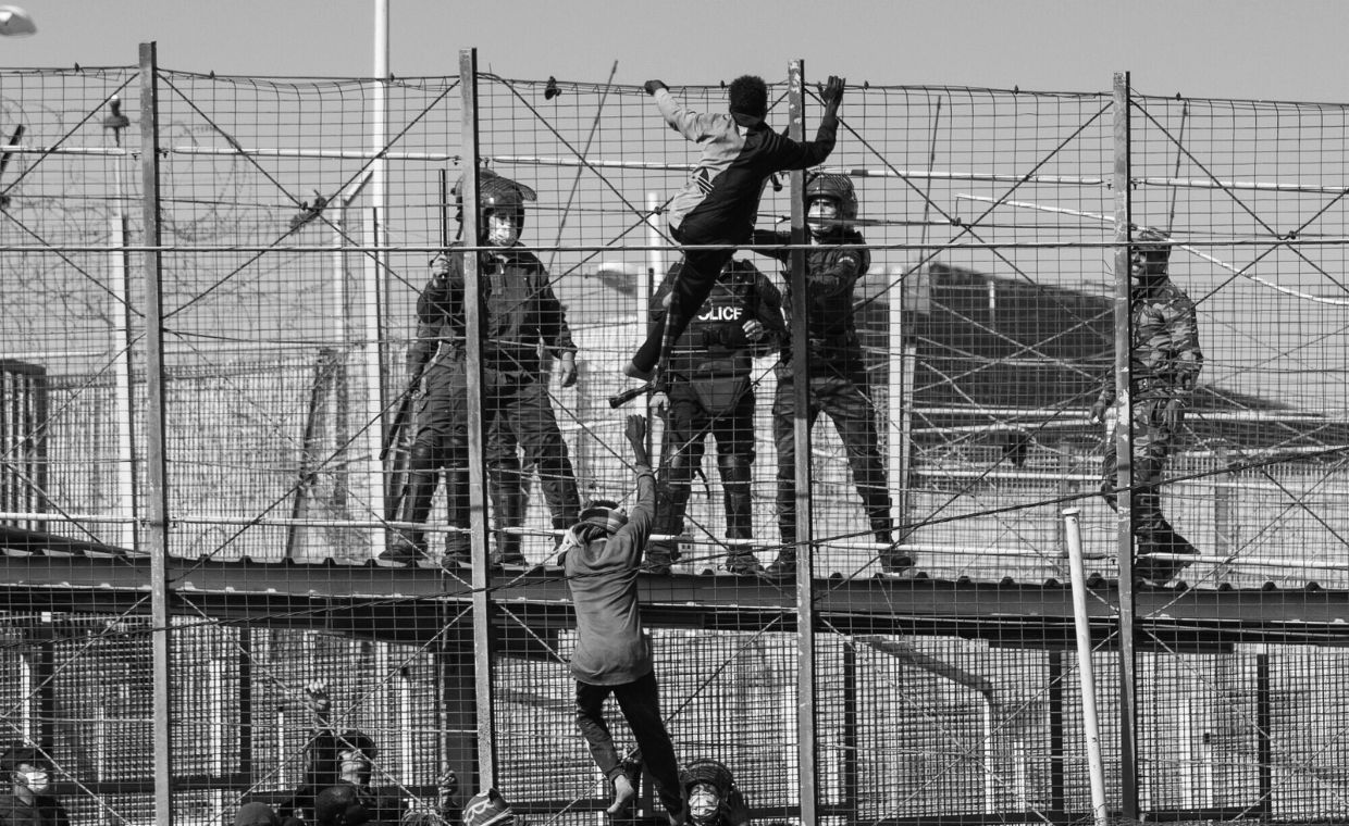 Melilla, masakra z 24 czerwca 2022 roku. Migranci wspinają się na płot graniczny