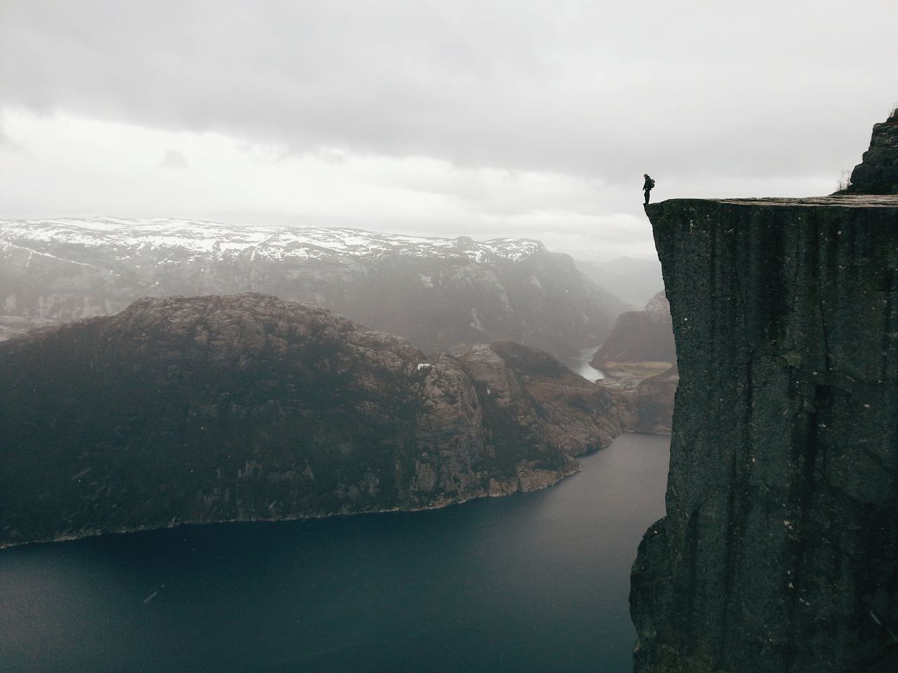 „On the edge" / Preikestolen, formacja skalna znana jako „modlitewnik", jest jedną z najczęściej odwiedzanych przyrodniczych atrakcji turystycznych w Norwegii. Preikestolen jest ogromne urwisko liczące 604 metrów. Ze względu na popularność tego miejsca w miesiącach letnich zdecydowaliśmy je odwiedzić kiedy tylko stopniał śnieg. O tej porze roku droga może być oblodzona w niektórych miejscach, a pogoda może się zmienić bardzo szybko od słońca, po deszcz i śnieg. Właśnie taka sytuacja zdarzyła się nam, ale mimo to dotarliśmy na szczyt. Widok był spektakularny. Aby wykonać to zdjęcie musiałem podejść bardzo blisko krawędzi i przyznaję, że aż zakręciło mi się w głowie. Zdjęcie zrobiłem moim smartfonem  i obrobiłem je za pomocą aplikacji VSCO Cam - chciałem uzyskać subtelny wygląda nie zmieniając naturalnych kolorów i światła.