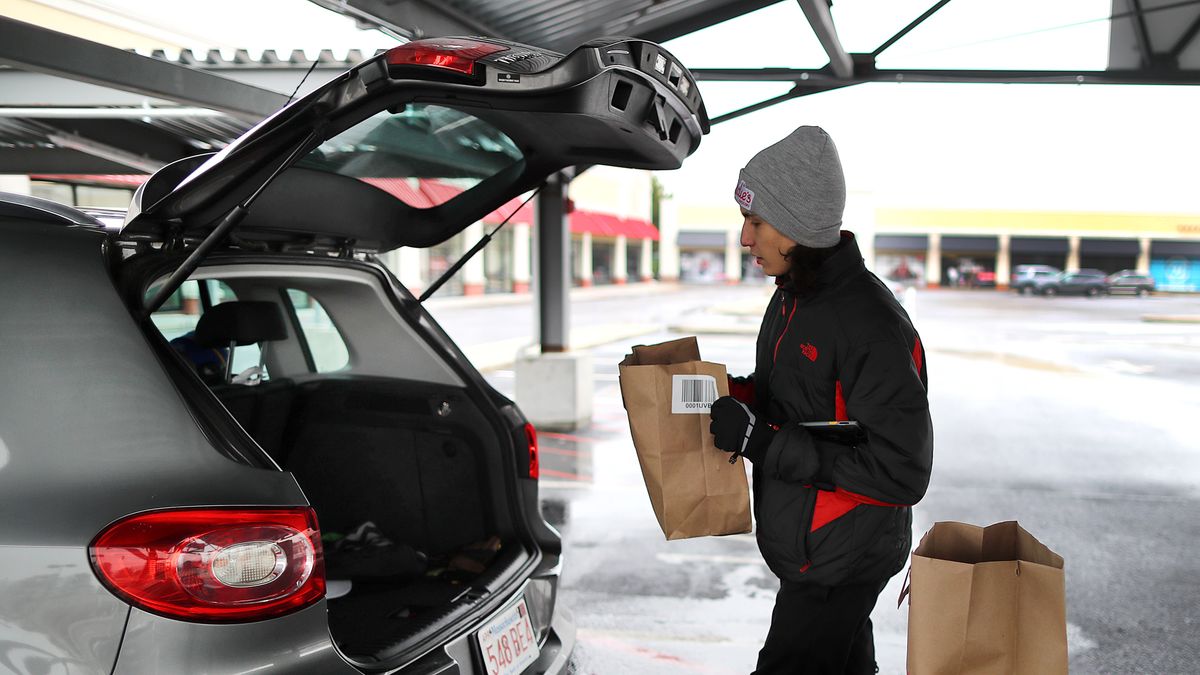 Norwood, MA - January 25: Worker Pedro De Oliveira loads filled grocery bags for an order outside at Addies, a drive-up only grocery store. They opened their first location in Norwood and have shelves and shelves stocked with every grocery item conceivable, and huge freezers and refrigerators with fresh produce and fruits and meats and frozen food. (Photo by John Tlumacki/The Boston Globe via Getty Images)