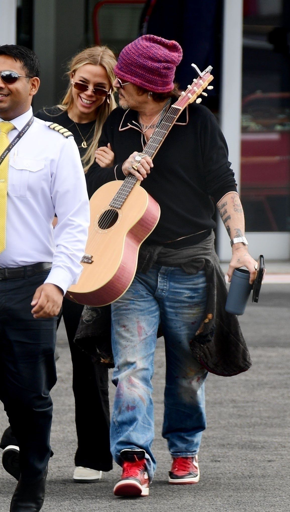 Johnny Depp rushes through the airport alongside a mysterious blonde woman