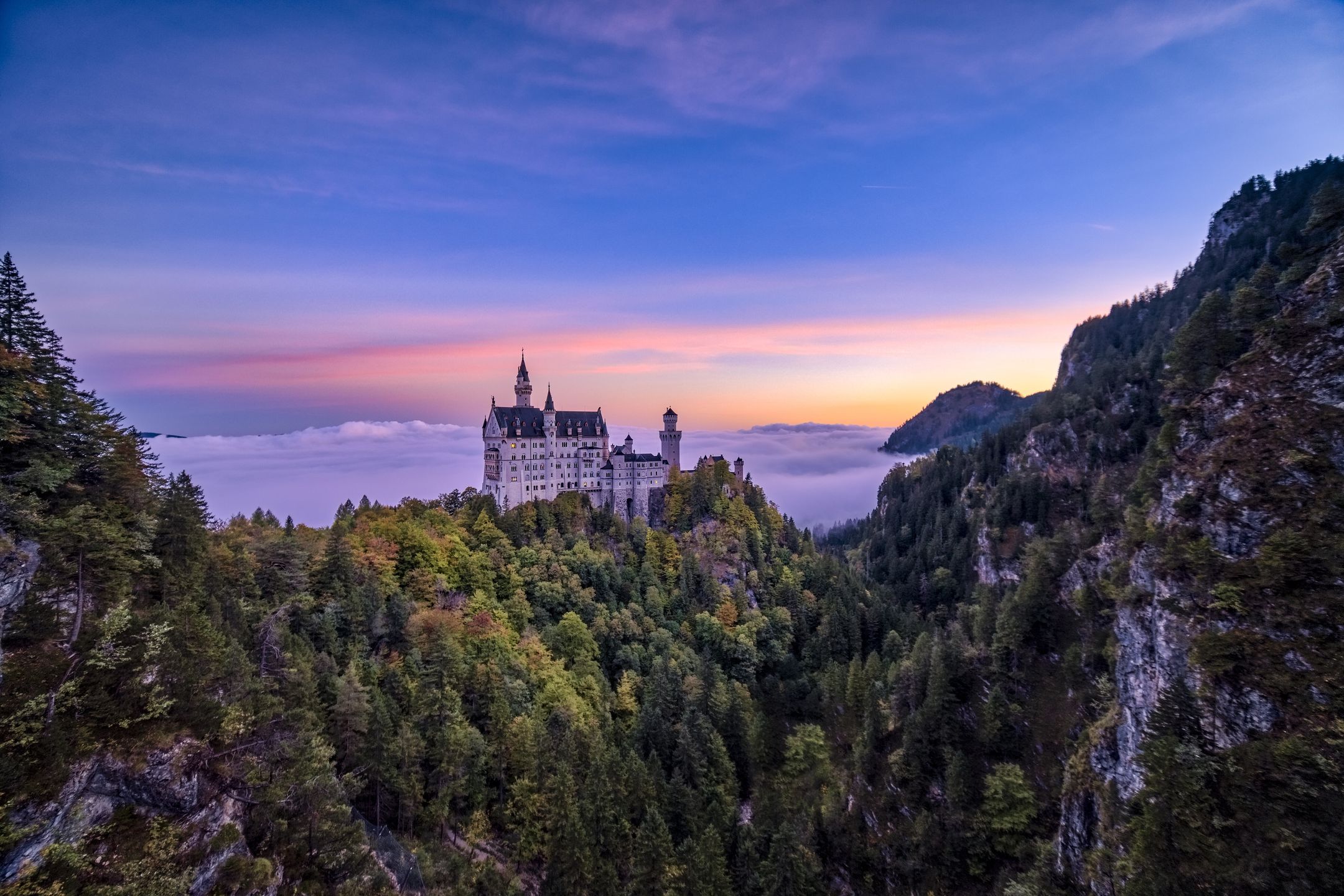 HOHENSCHWANGAU, BAVARIA, GERMANY - 2023/10/16: (EDITORS NOTE: Exposure latitude of this image has been digitally increased.) The castle Neuschwanstein, seen from the bridge Marienbrücke at sunrise in autumn, rising out of the fog. (Photo by Frank Bienewald/LightRocket via Getty Images)