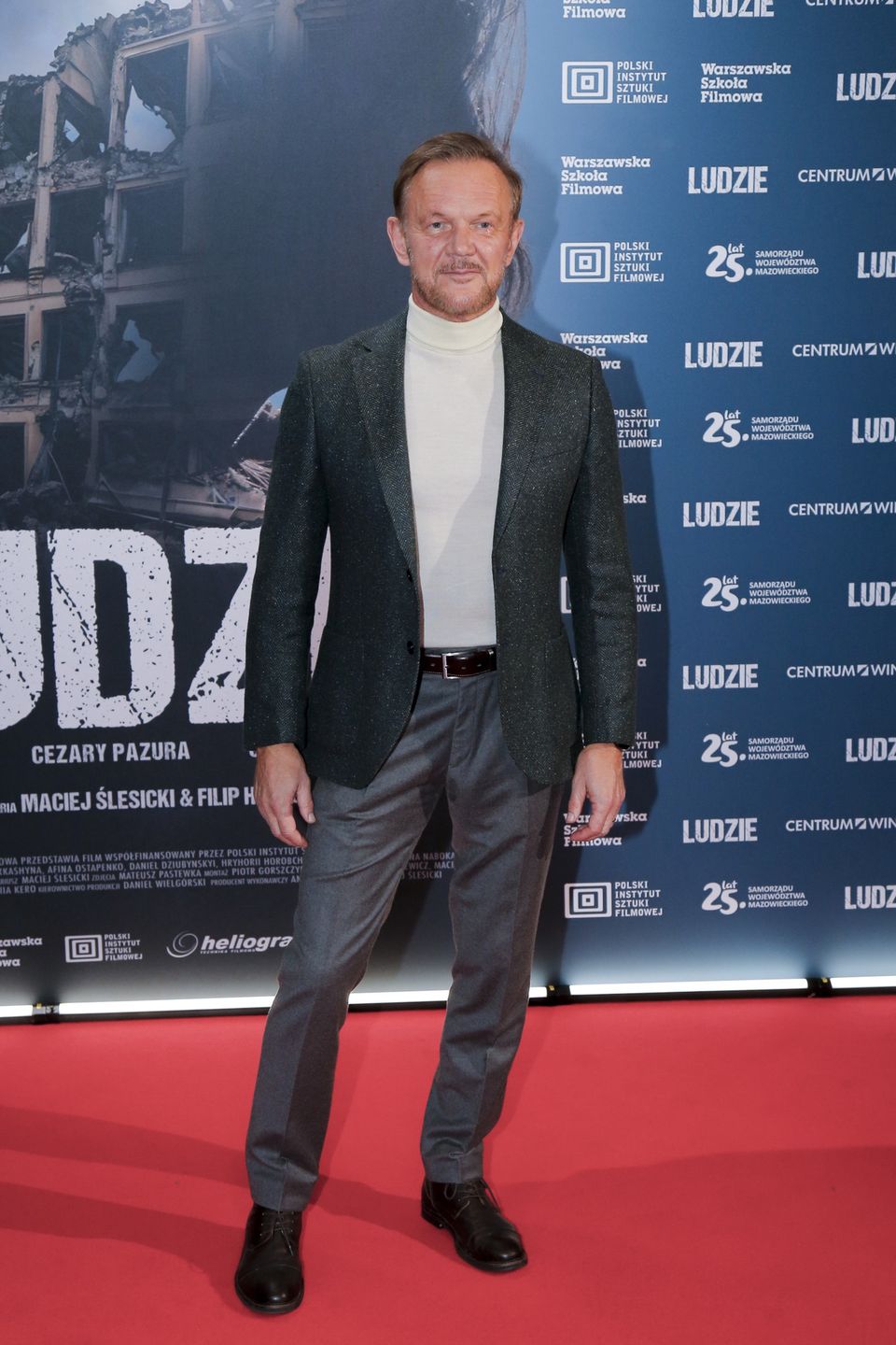 film, ludzie, "Ludzie" - pokaz specjalny filmu, luty 2024, pokaz, pokaz filmu, pokaz specjalny, buty czarne, spodnie szare, marynarka zielona, Cezary Pazura