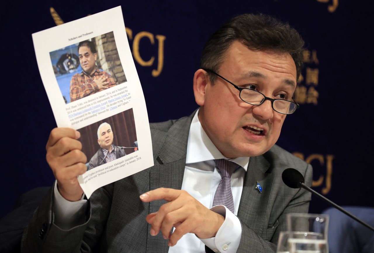 Dolkun Isa, President of World Uyghur Congress, shows pictures of Uyghur people that have been inprisoned in camps during a press conference at the Foreign Correspondents' Club of Japan in Tokyo, Japan, 20 November 2018