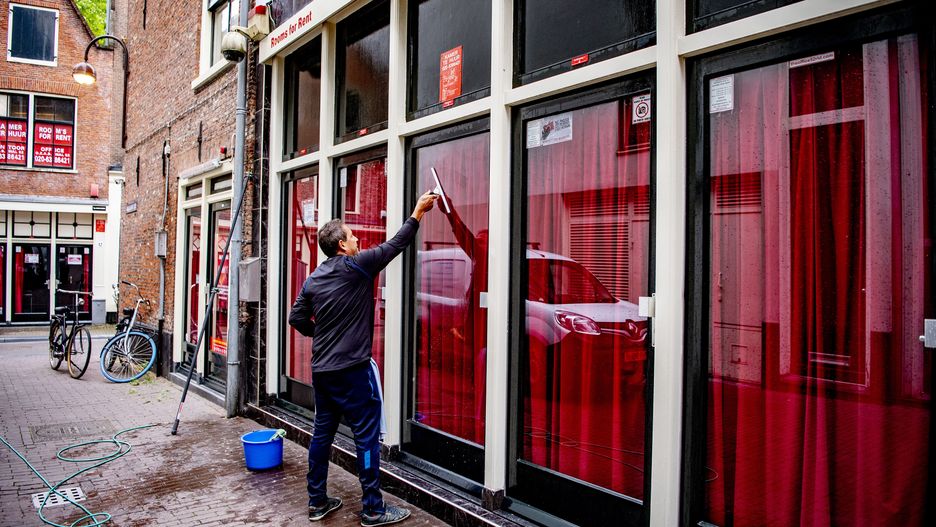 AMSTERDAM, NETHERLANDS - 2020/06/30: A worker cleaning glass windows on a sex workers' building during the preparations.The Wallen, famous red light district in Amsterdam is preparing for the opening as sex workers get back to work. A mask is not required for a customer to put on. (Photo by Robin Utrecht/SOPA Images/LightRocket via Getty Images)