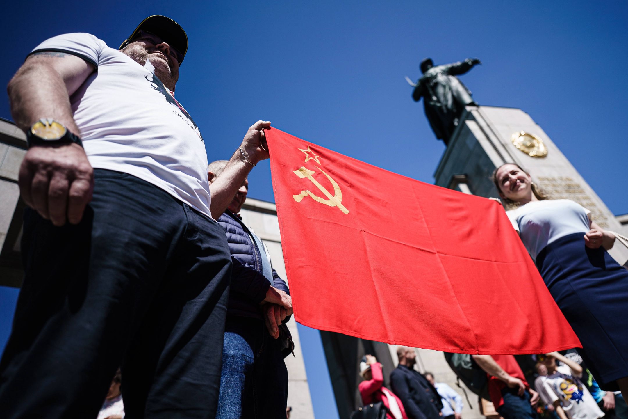 Victory Day commemorations in Berlinepa09935847 Visitors pose with a Soviet flag at the Soviet War Memorial at Tiergarten Park during a commemoration ceremony for the fallen Soviet soldiers during World War II at the Brandenburg Gate in Berlin, Germany, 09 May 2022. The Berlin regional senate banned the showing of Ukrainian and Russian flags near memorials during the weekend of the 77th anniversary of the end of second World War in Germany, to avoid instrumentalization of symbols in correlation to the ongoing war in Ukraine. Nazi Germany formally surrendered on 08 May 1945. At that time in Moscow, Russia, the 09 May had already begun, why Russians commemorate the victory over Nazi Germany on 09 May.  EPA/CLEMENS BILAN Dostawca: PAP/EPA.CLEMENS BILAN