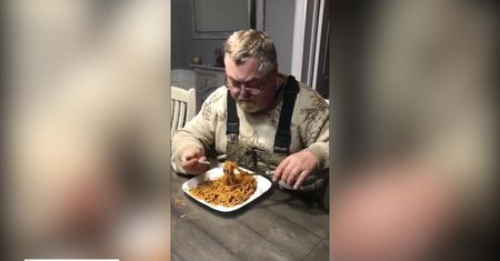 Głodny mężczyzna tnie sobie spaghetti nożyczkami, żeby było… szybciej